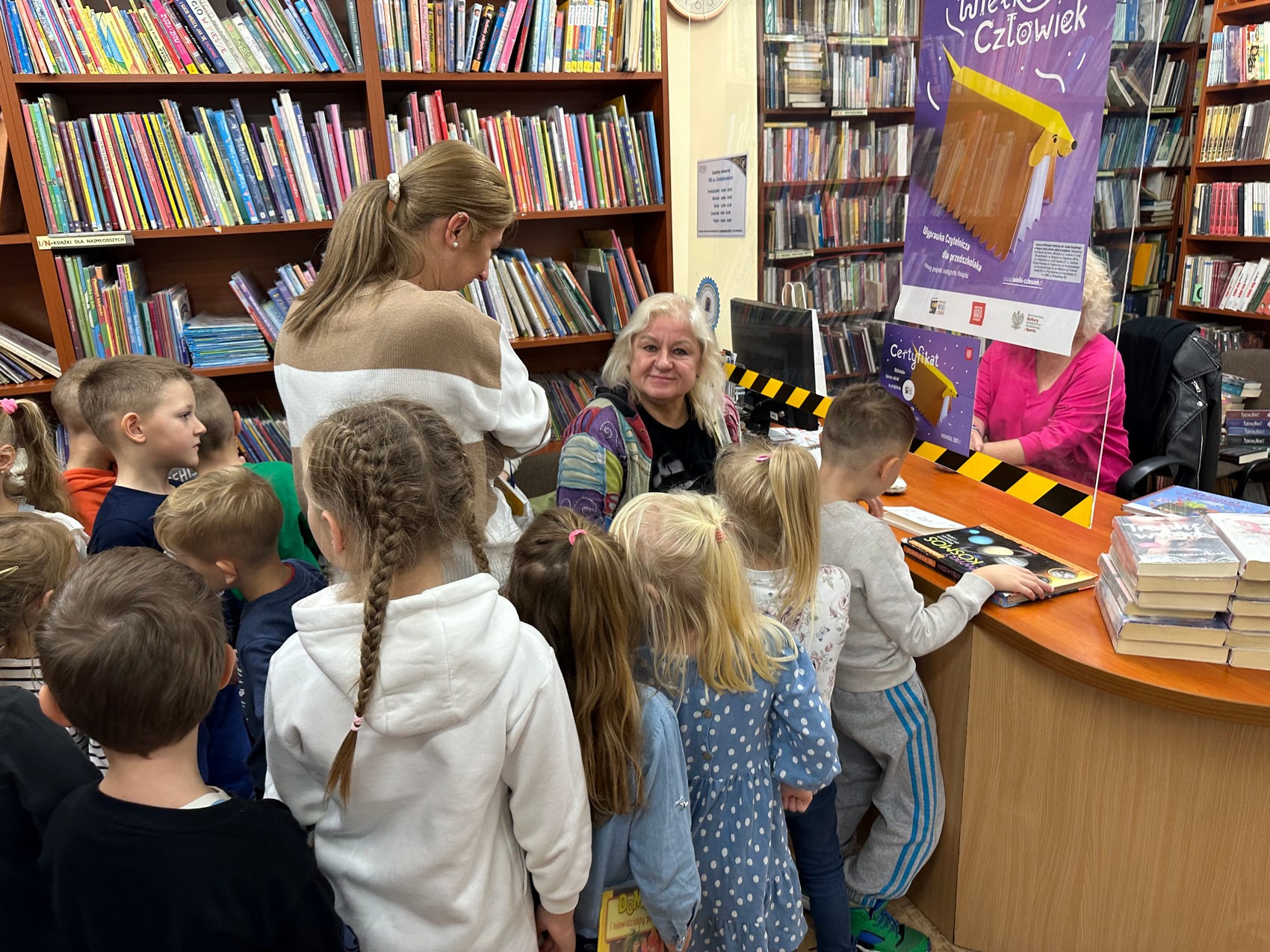 Sądeczanki_Babiarz_4 Kolejka dzieci w bibliotece i trzy kobiety.