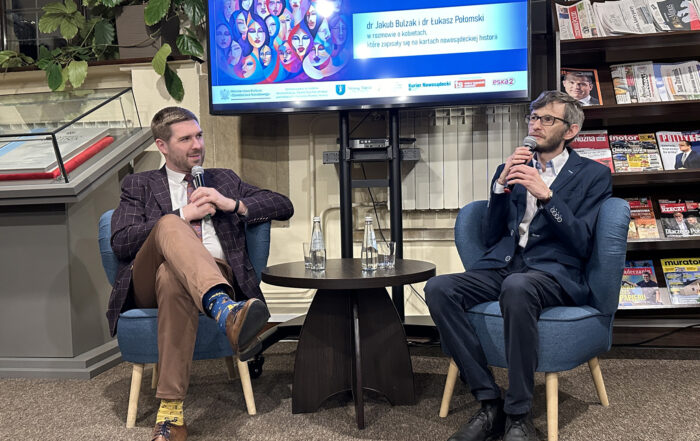 Dwóch mężczyzn mówi do mikrofonu.