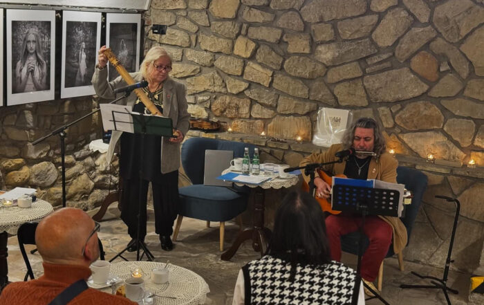 Mężczyzna i kobieta występujący w piwnicach. Przed nimi siedzą ludzie i wsłuchują się.