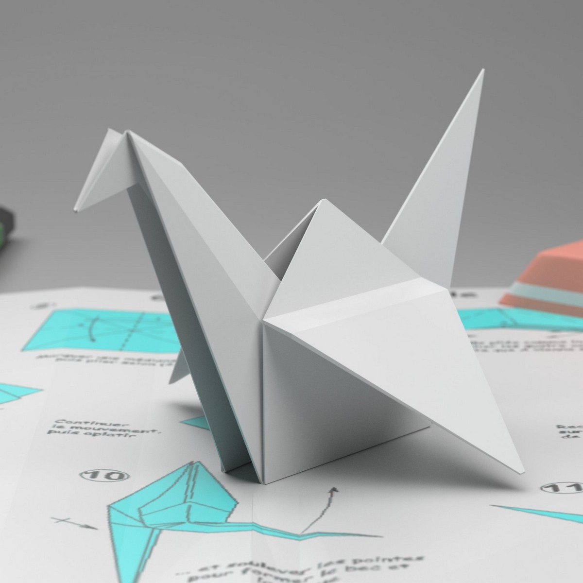 Na rozłożonej instrukcji składania origami stoi złożony z origami biały łabędź.