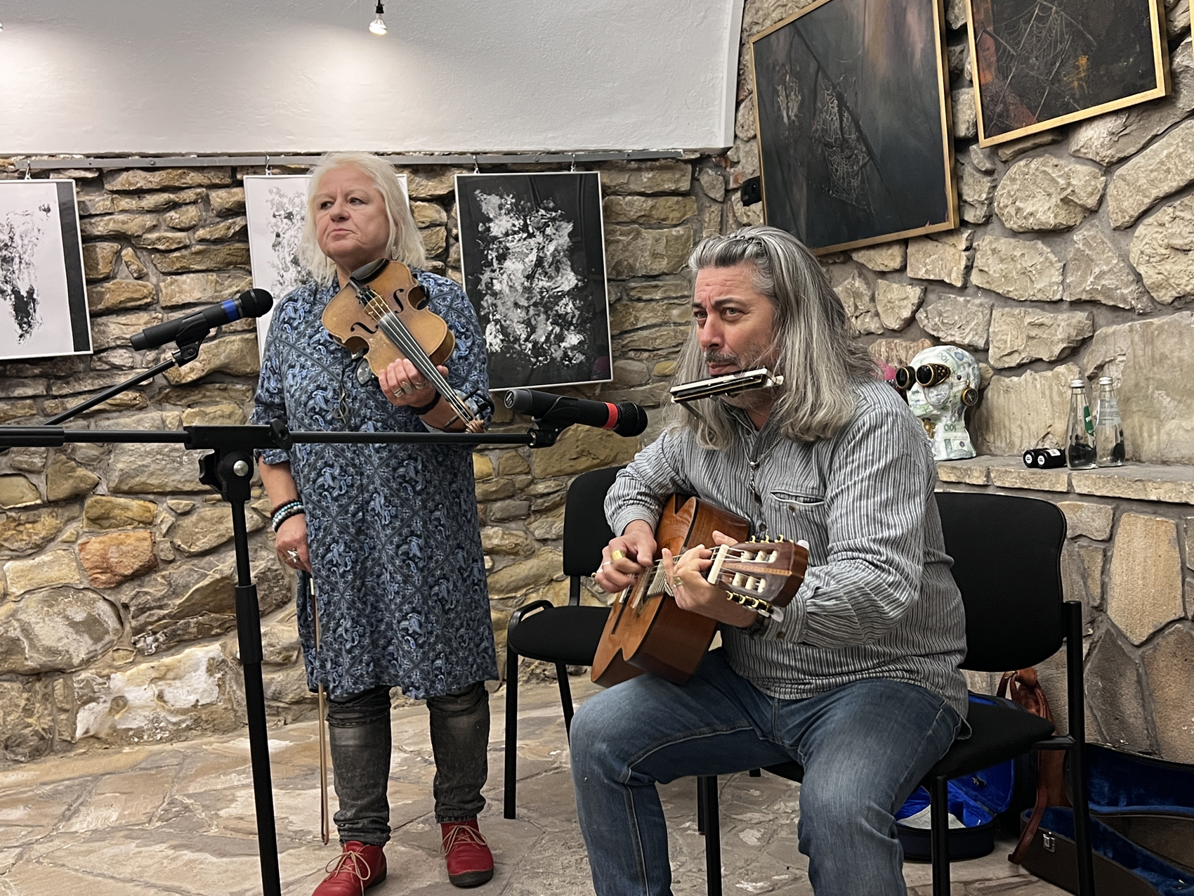 Dialogi malarskie – wystawa (2) Mężczyzna gra na gitarze, towarzyszy mu kobieta grająca na skrzypach