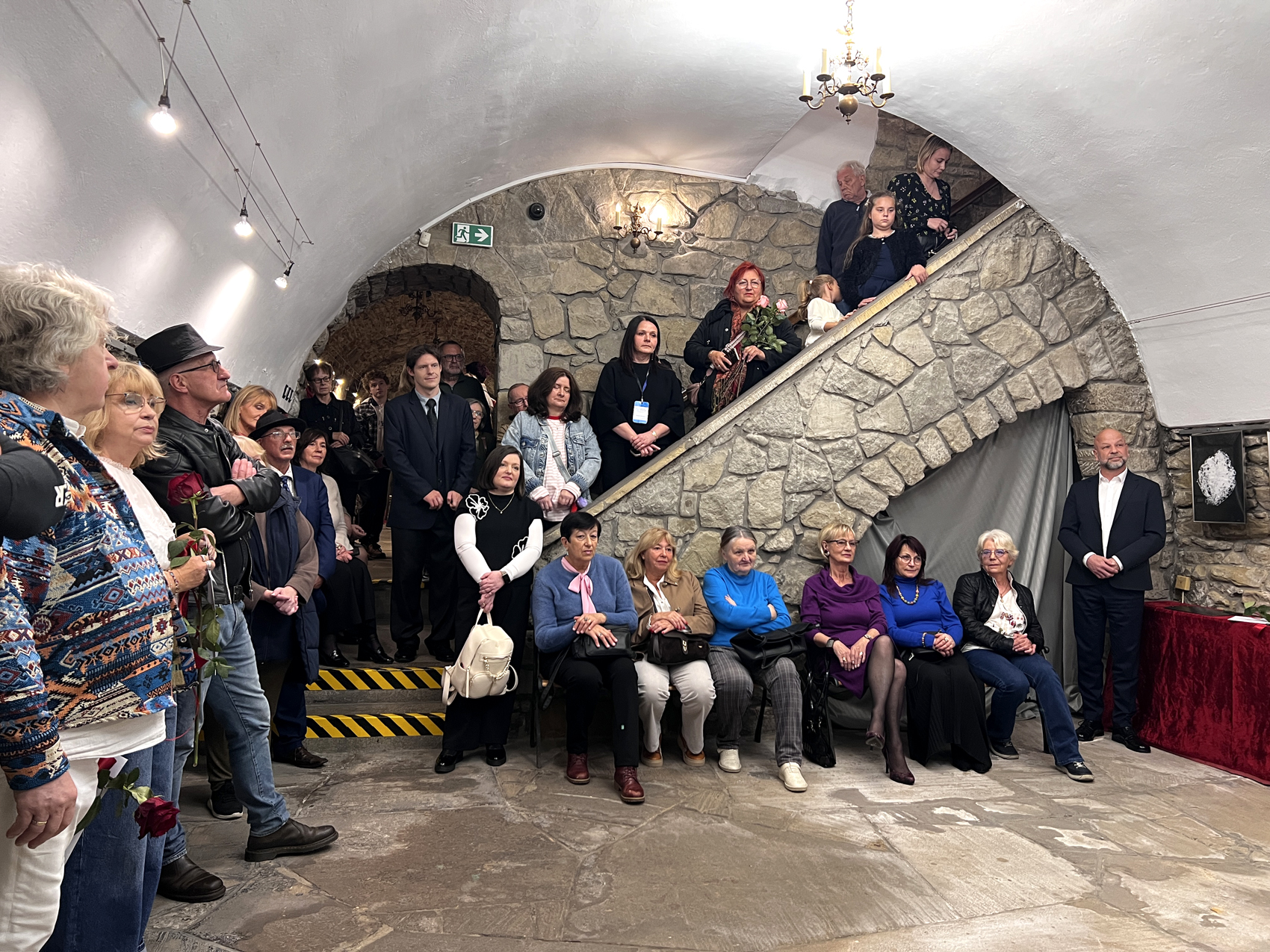 Dialogi malarskie – wystawa (3) Grupa uczestników wystawy pozuje do zdjęcia z kwiatami